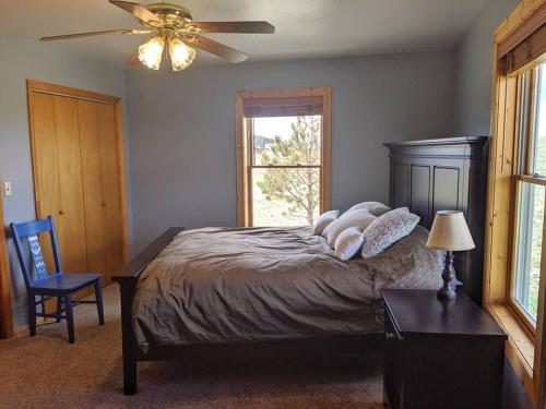a bedroom with a bed with a ceiling fan and a window at Beautiful quiet getaway in dark skies community. Perfect for a relaxing stay in the mountains in Westcliffe