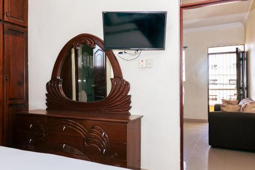 a wooden dresser with a mirror and a tv on it at BNB Family Vacation Rentals, Corales del Sur, Santo Domingo Este in La Viva