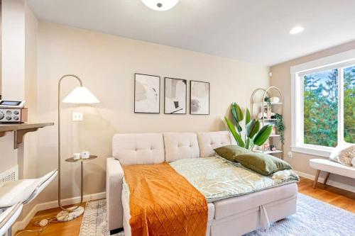 1 dormitorio con cama blanca y manta naranja en Prime Northgate Retreat near mall I-5 Light Rail en Seattle