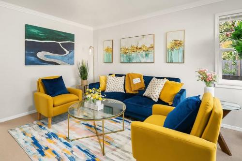 a living room with a blue couch and yellow chairs at Hidden Getaway Family House - UW - Children Hospital in Seattle