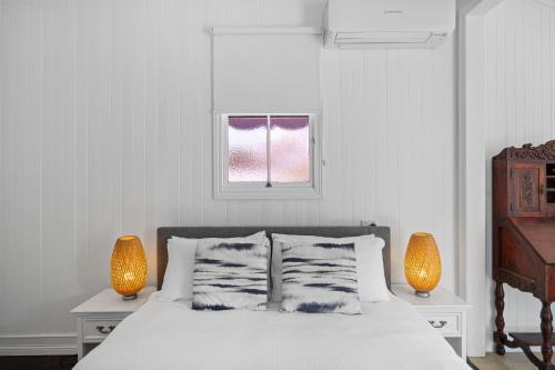 a bedroom with a bed with two lamps and a window at "Xanadu" Charming 2-Bed Retreat by Marcoola Beach in Bli Bli