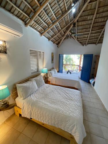 1 dormitorio con 2 camas y balcón en VillasMana Complex PlayaBonita LasTerrenas Samana NearBeach WiFi, en Las Terrenas