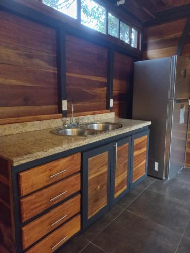 a kitchen with a sink and a refrigerator at Arenal Getaway in Fortuna