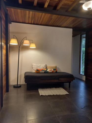 a bedroom with a bed with a lamp and a floor at Arenal Getaway in Fortuna