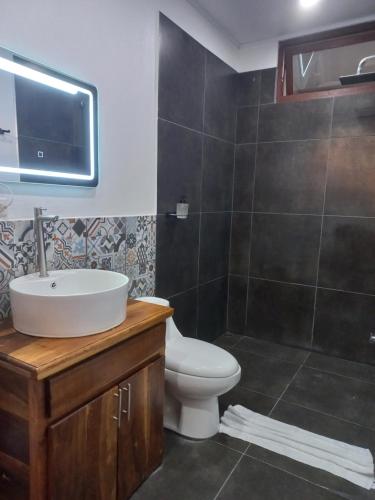 a bathroom with a sink and a toilet at Arenal Getaway in Fortuna