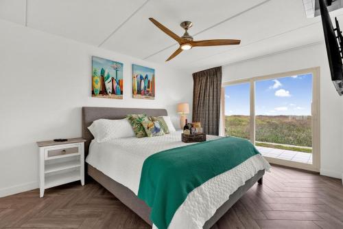 sypialnia z łóżkiem i wentylatorem sufitowym w obiekcie Seagull Beachfront Condominiums w mieście South Padre Island
