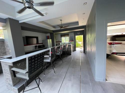 a kitchen with a bar with chairs and a car at Michelle house pool villa in Pattaya South