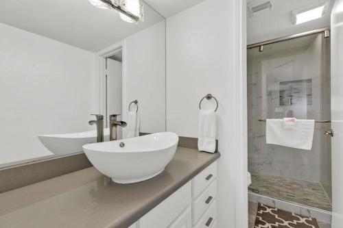 a white bathroom with a sink and a shower at Seagull Beachfront Condominiums in South Padre Island