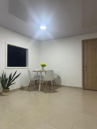 uma sala de jantar com uma mesa e cadeiras e uma televisão em Leonor’s Guest House em Providencia