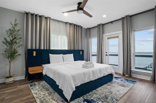 a bedroom with a blue bed with a view of the ocean at Waterfront Home with Views - Hot Tub & Movie Theatre in Bacliff