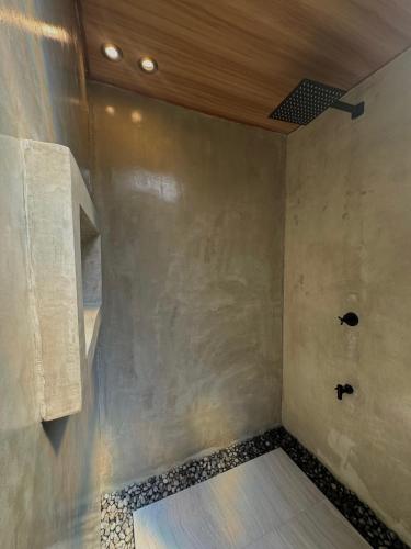 a bathroom with a shower with a wooden ceiling at Your Brothers House Tribal Village in Legazpi