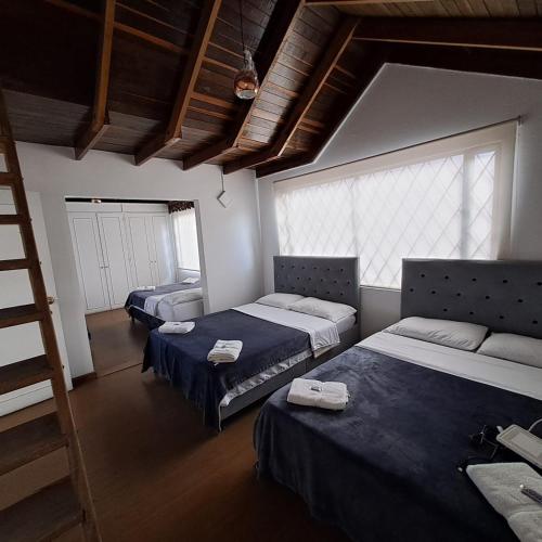 a bedroom with two beds and a ladder at Fortaleza Diosa Chia in Chía