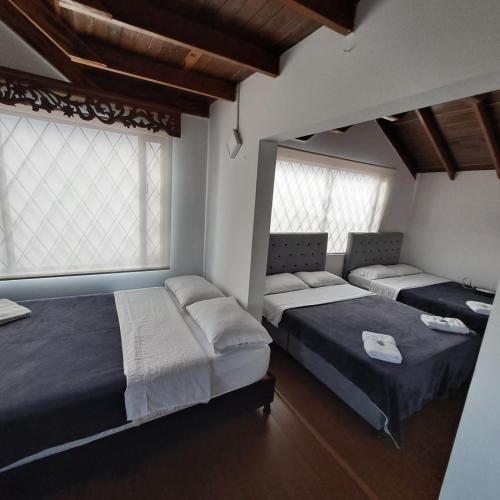 a bedroom with two beds and two windows at Fortaleza Diosa Chia in Chía