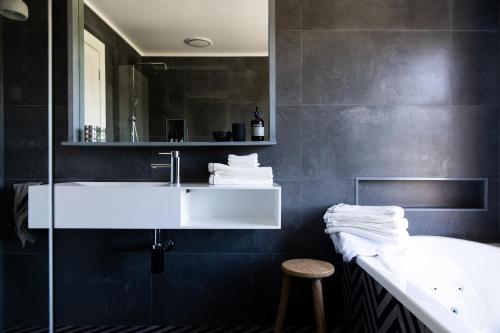 een badkamer met een witte wastafel en een spiegel bij Fingal House in Fingal