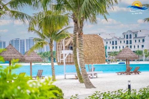 een resort met een strand met stoelen en palmbomen bij Homestay Vinhomes Ocean Park S209 in Ða Tốn