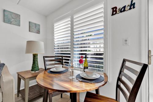 a dining room with a wooden table and chairs at Beachside Bungalow: Surfside I #104 in South Padre Island