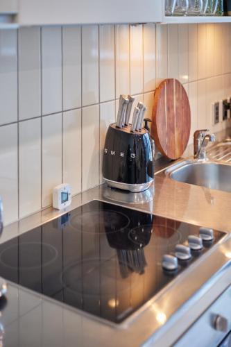 a kitchen with a toaster on a counter next to a sink at Pavilions Marina Apartment 102 - Wynyard Quarter Viaduct Harbour in Auckland