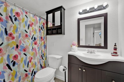 a bathroom with a toilet and a sink and a shower curtain at Beachside Bungalow: Surfside I #104 in South Padre Island