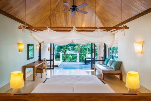 a bedroom with a bed and a ceiling fan at Sheraton Hua Hin Pranburi Villas in Pran Buri