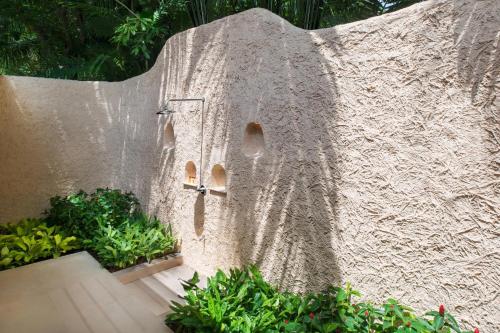 a stone wall with a door and some plants at Sheraton Hua Hin Pranburi Villas in Pran Buri
