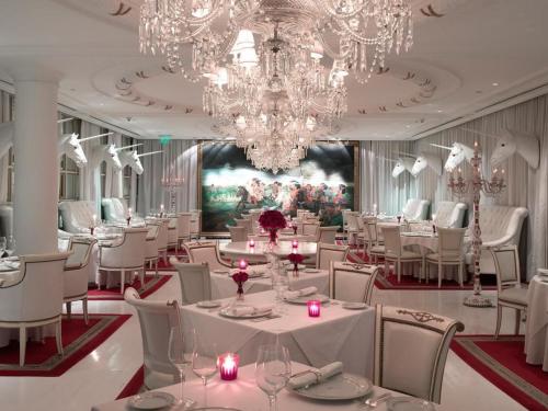 a restaurant with white tables and chairs and chandeliers at Departamento en Residencias Faena in Buenos Aires