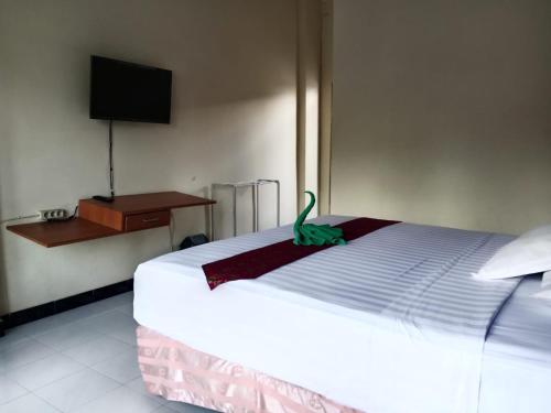 a bedroom with a bed with a green dinosaur on it at Grand Palem Hotel in Songgoriti