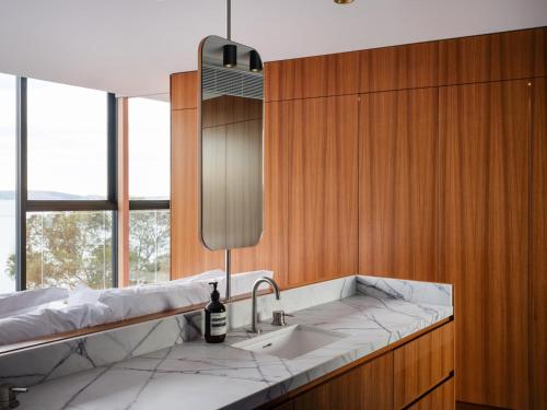 a bathroom with a sink and a large window at 'Hobart' - Waterfront penthouse with private heated pool in Hobart