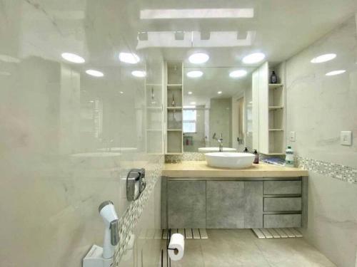 een witte badkamer met een wastafel en een bad bij Fully Furnished Apartment-HEART OF LEBLON (Apartamento Totalmente mobiliado no melhor ponto do leblon) in Rio de Janeiro
