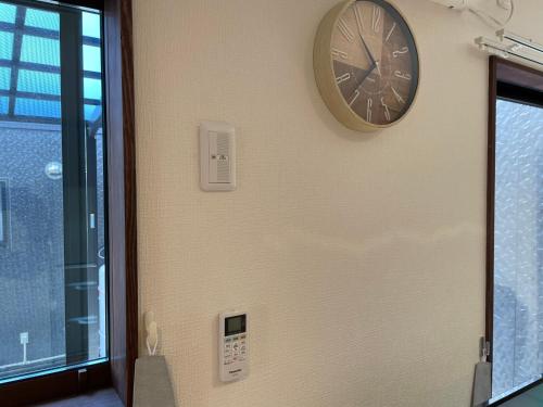 a clock on the side of a wall at 一棟貸しnuevoL7～暮らすように泊まる北群馬の冒険はここから in Numata