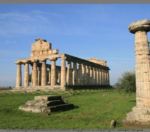 un antiguo templo con una columna y un poste en Lory&B, en Capaccio-Paestum