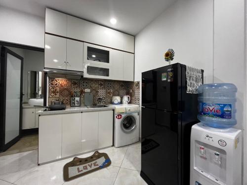 eine Küche mit einem schwarzen Kühlschrank und einem Geschirrspüler in der Unterkunft Apartment 285 Đội Cấn, Hà Nội in Hanoi