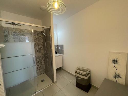 La salle de bains est pourvue d'une douche et d'une cabine de douche en verre. dans l'établissement Charmante maison neuve 3 chambres, WIFI, proche forêt domaniale, avec jardin et parking privé - FR-1-323-538, à Saint-Jean-de-Monts