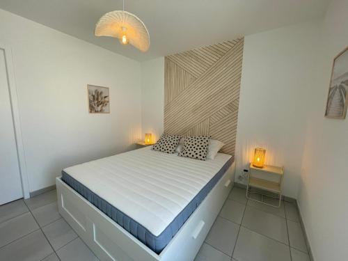 - une chambre dotée d'un lit avec deux lumières dans l'établissement Charmante maison neuve 3 chambres, WIFI, proche forêt domaniale, avec jardin et parking privé - FR-1-323-538, à Saint-Jean-de-Monts