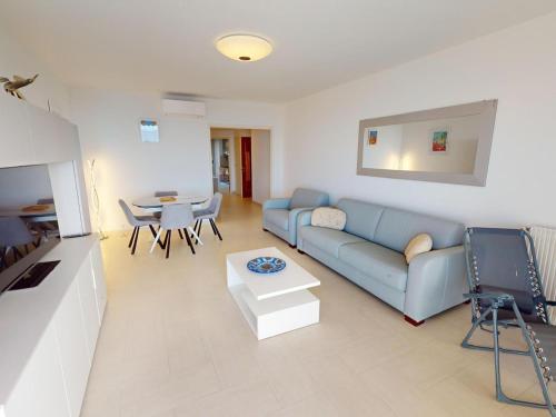 un salon avec un canapé bleu et une table dans l'établissement Magnifique 2P climatisé face mer avec 2 terrasses, garage, et Wifi – Menton - FR-1-196-352, à Menton