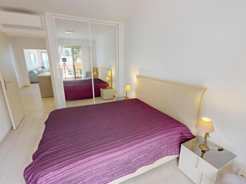 une chambre avec un lit violet et un miroir dans l'établissement Magnifique 2P climatisé face mer avec 2 terrasses, garage, et Wifi – Menton - FR-1-196-352, à Menton