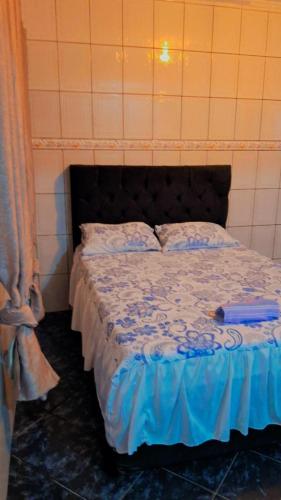 a bedroom with a bed with a blue comforter at kitnet casa completa in Guarulhos