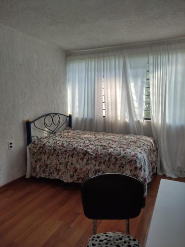 1 dormitorio con cama, ventana y silla en Habitaciones ampliación piloto, en Ciudad de México