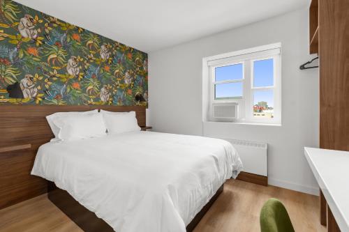 a bedroom with a large white bed and a window at Uptown Inn - Limited Service Apart-Hotel in San Diego