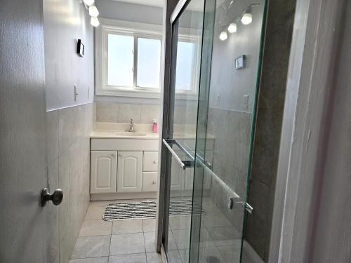 W łazience znajduje się prysznic i umywalka. w obiekcie Modern Quiet Home By the Airport w mieście Mississauga