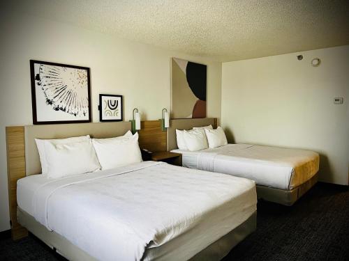 a hotel room with two beds with white sheets at Greenwood Inn in Greenwood Village