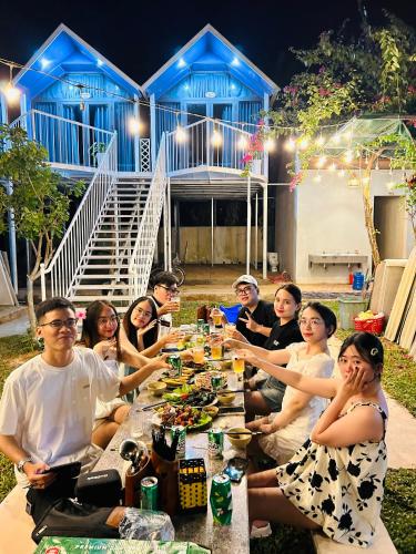 a group of people sitting around a long table at Son River House in Phong Nha