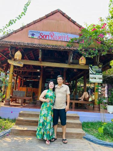 a man and a woman standing in front of a building at Son River House in Phong Nha
