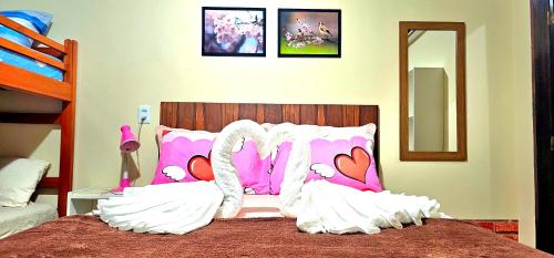 a bedroom with a bed with pink and white pillows at Hotel Cida Homes - Apartamento Charmoso com 300 Mbps in Boa Vista