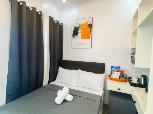 ein kleines Schlafzimmer mit einem Bett mit ausgestopftem Tier drauf in der Unterkunft Ronina's Sipocot Hotel in Sipocot