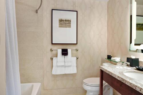La salle de bains est pourvue d'un lavabo, de toilettes et d'une photo. dans l'établissement The Algonquin Resort St. Andrews by-the-Sea, Autograph Collection, à Saint Andrews
