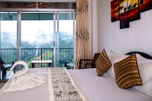 a bedroom with a bed with a view of a balcony at New Ella Nature View in Ella