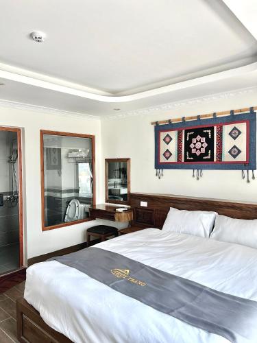 een slaapkamer met een groot bed en een spiegel bij Thùy Trang Hotel Sapa - by Bay Luxury in Sa Pa