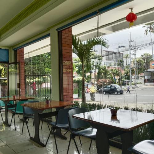 a patio with tables and chairs and a view of a street at Grand Palem Hotel in Songgoriti