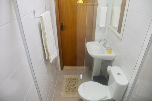 Un baño blanco con inodoro y lavabo. en Chalé Shakti, en Teresópolis
