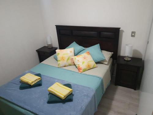 a bedroom with a blue bed with yellow and blue pillows at Arica verano y surf Dpto completo 2 habitaciones in Arica